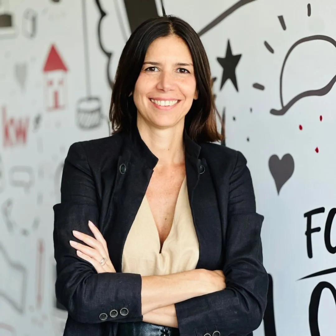 Stella Marengo sonriendo frente a la pizarra de casitas dibujadas de su oficina en Tigre